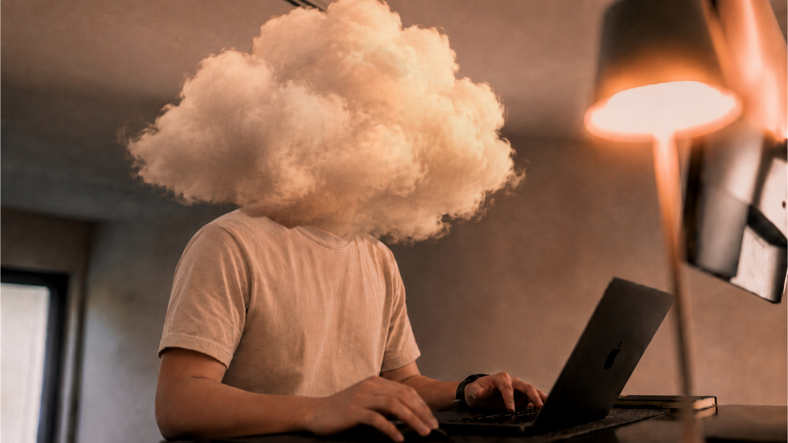 Alviss working on a laptop with a cloud mask over the face